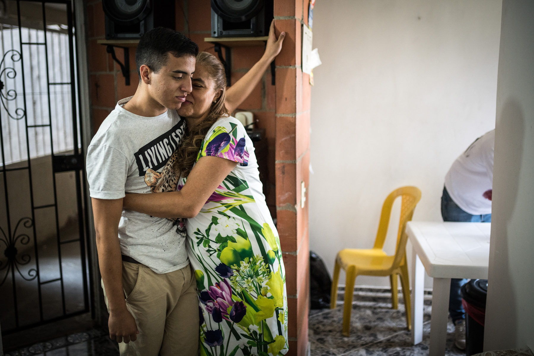 His mother Martha embraces her son. Daniel lives with his family high up on a steep slope of Medellín in a social settlement. He shares the room with his brother. The whole family is standing strong together so that Daniel's dream can come true.