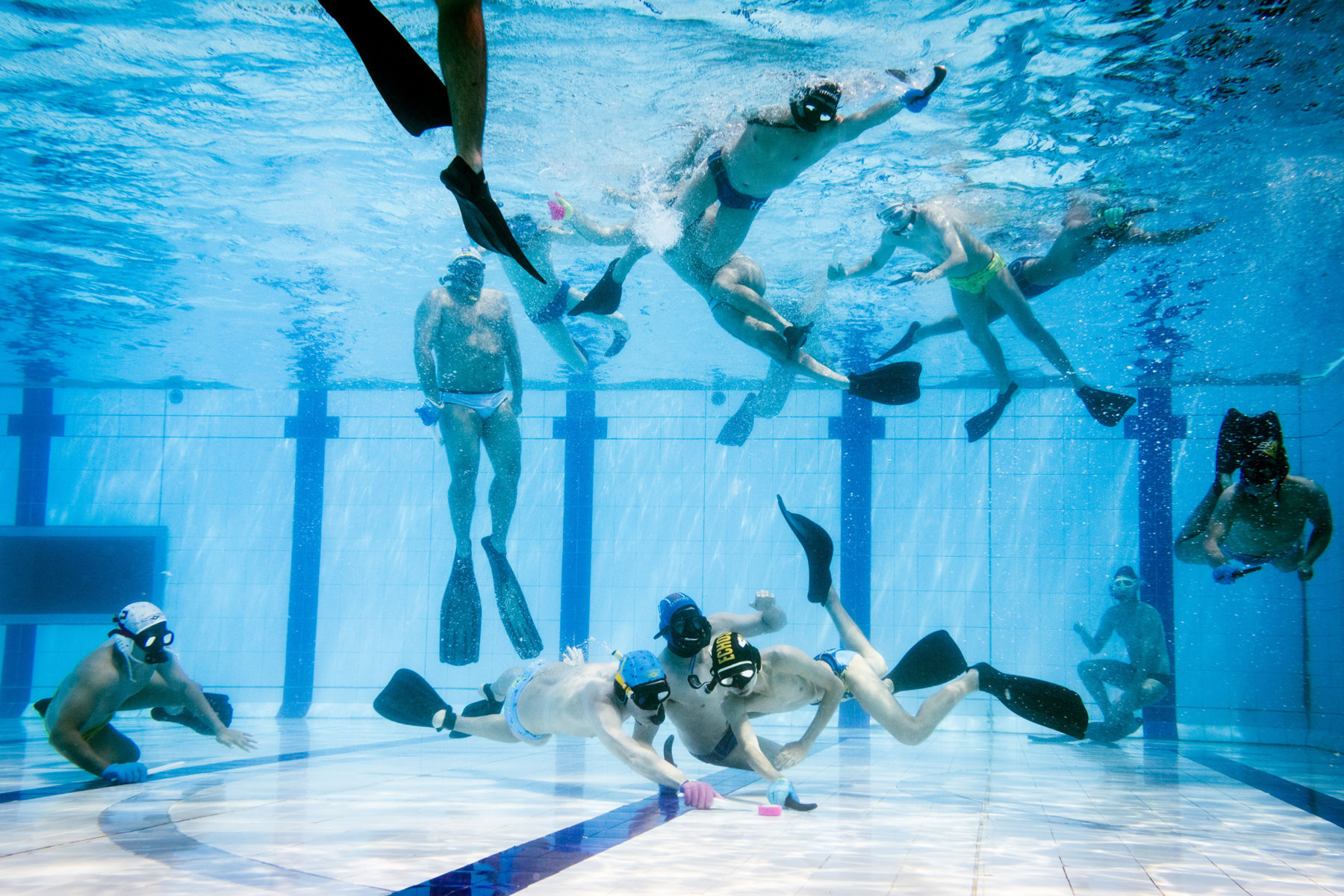 The players swim on the surface, watch the game, and dive down as soon as they see a possibility to intervene.